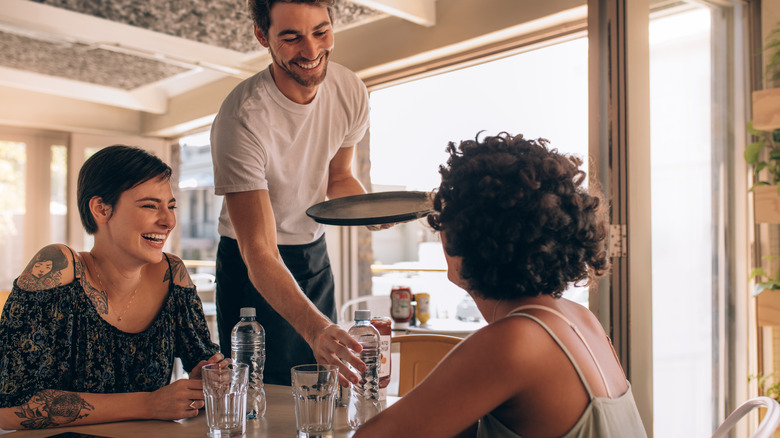 Women smiling with waiter