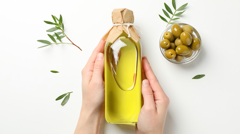 Woman holding bottle of olive oil