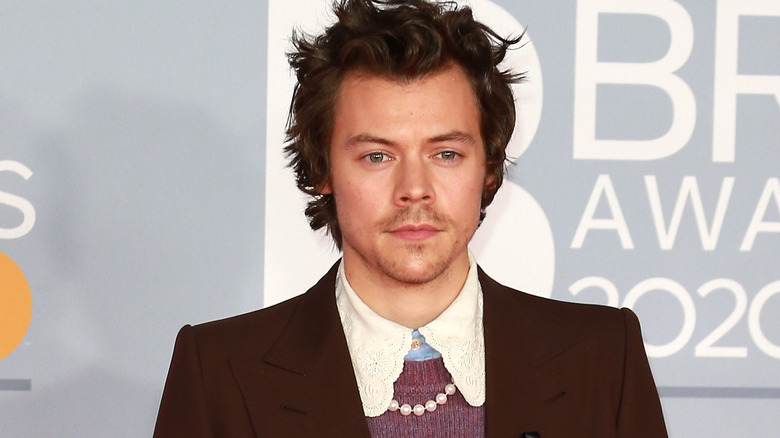 Harry Styles wearing a pearl necklace on the red carpet