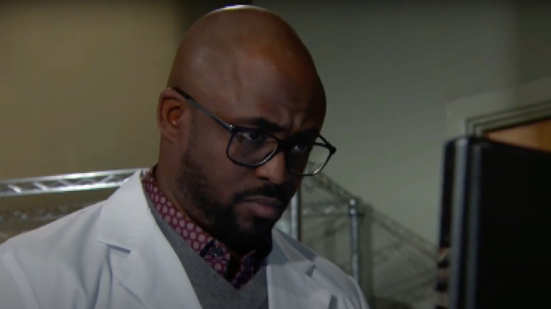 Wayne Brady wearing glasses and a lab coat