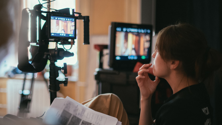 woman watching camera on film set