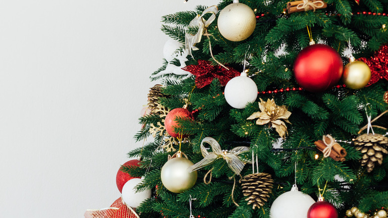 Artificial Christmas tree with red and gold ornaments hanging on it