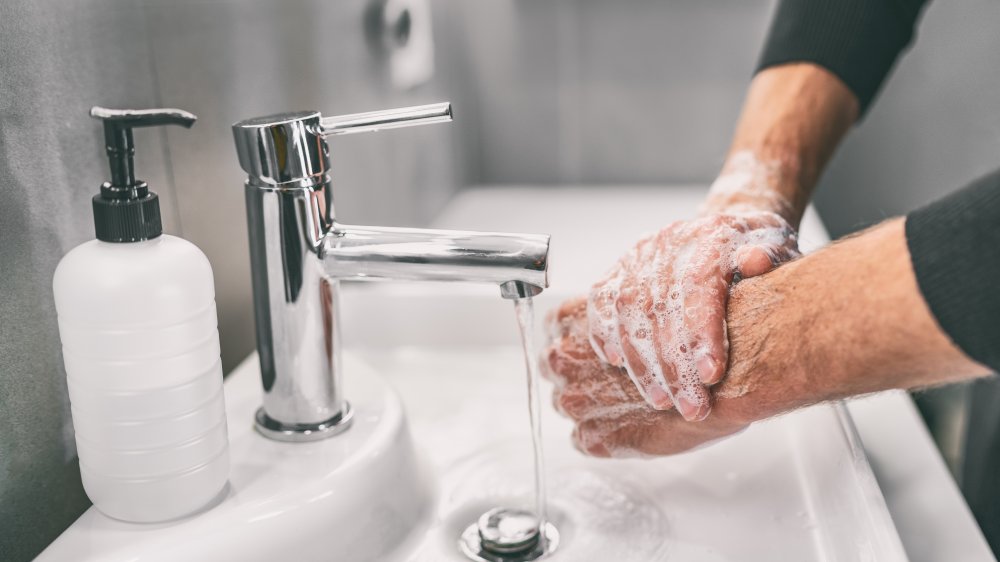 man washing hands with soap and water