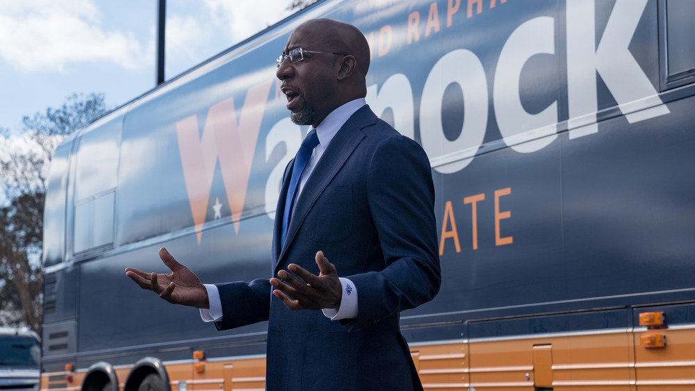 Raphael Warnock in front of bus
