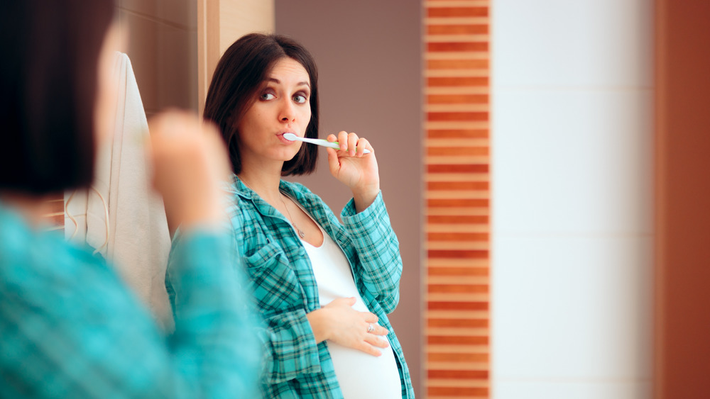 Pregnant woman brushing teeth