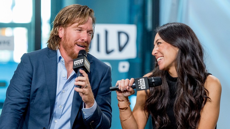 Chip and Joanna Gaines holding microphones