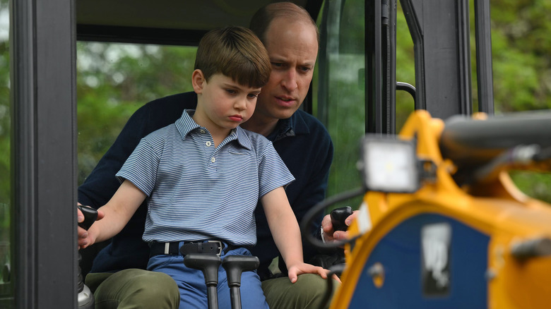 Prince Louis sitting on William, Prince of Wales' lap and driving a digger