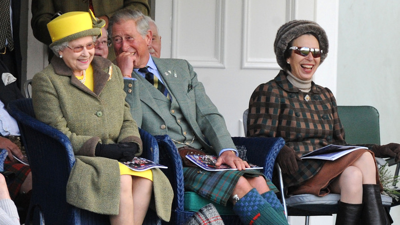 Queen Elizabeth sits next to laughing Prince Charles and Princess Margaret