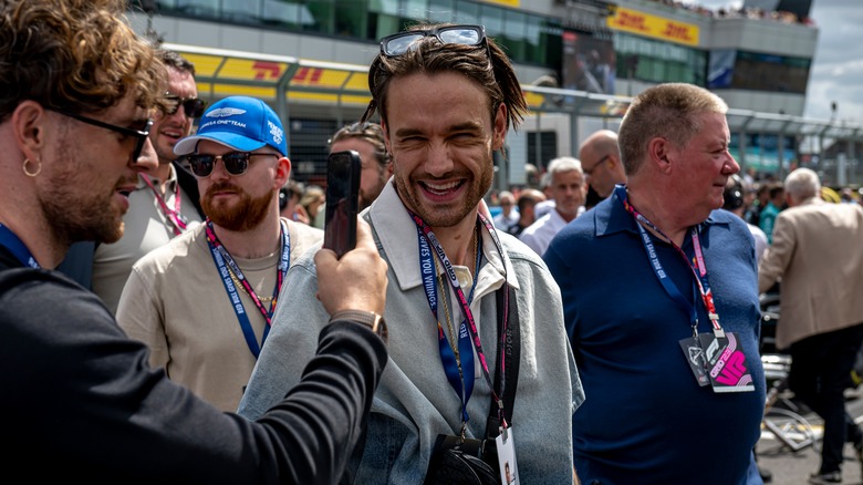 Liam Payne laughing at F1 event.