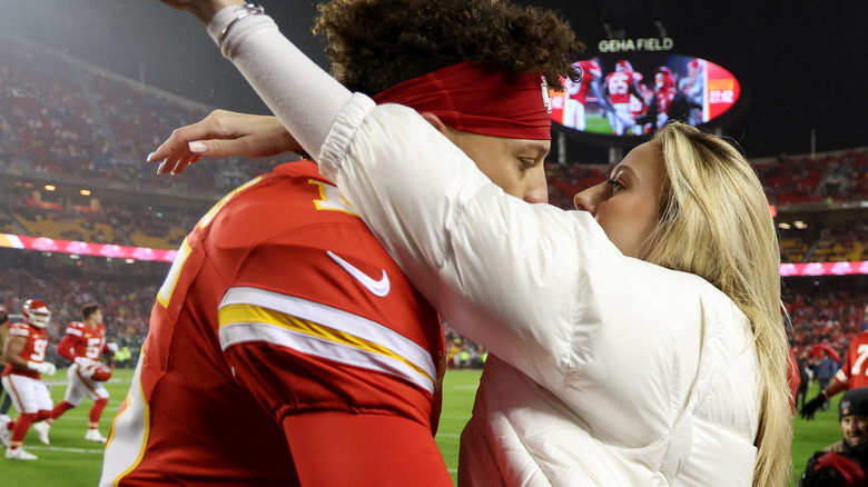 Brittany and Patrick embrace on the football field