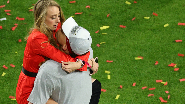 Brittany Mahomes and Patrick Mahomes embrace on the field after Super Bowl LIV