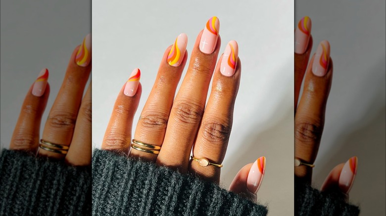 Single hand showing orange, yellow, and pink swirl design