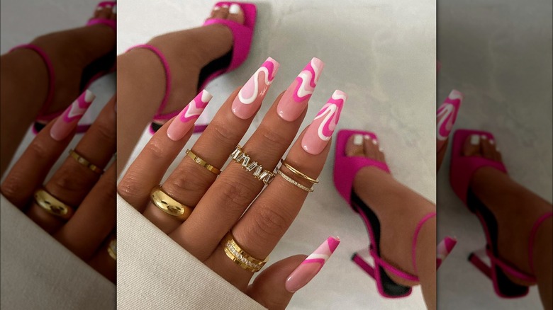 Hand showing pink swirly nail design