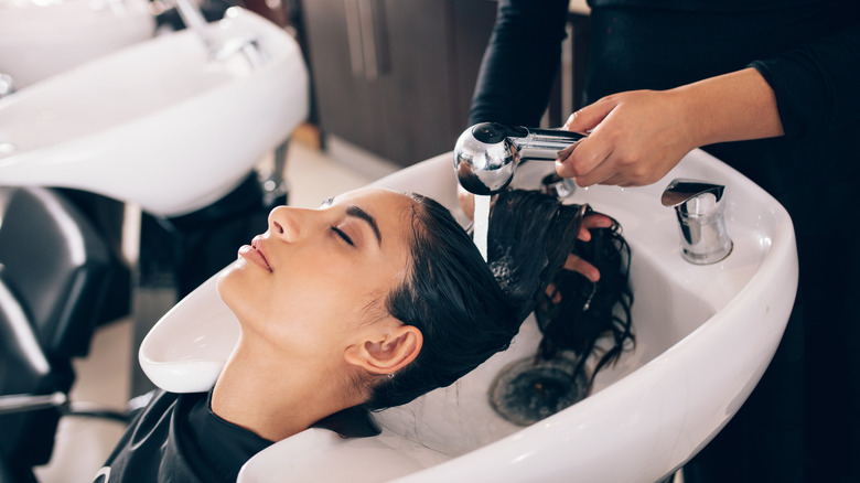 Hairdresser washing customer's hair