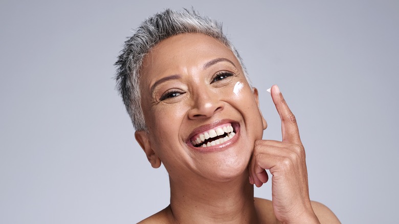 senior woman applying sunscreen