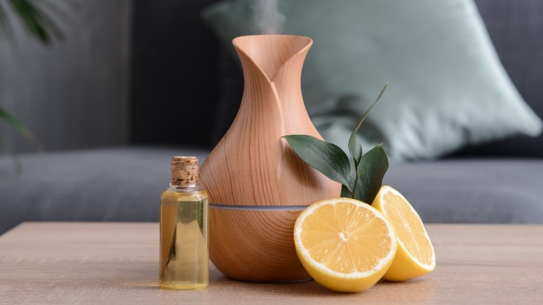 An essential oil diffuser with essential oil bottle and sliced lemon