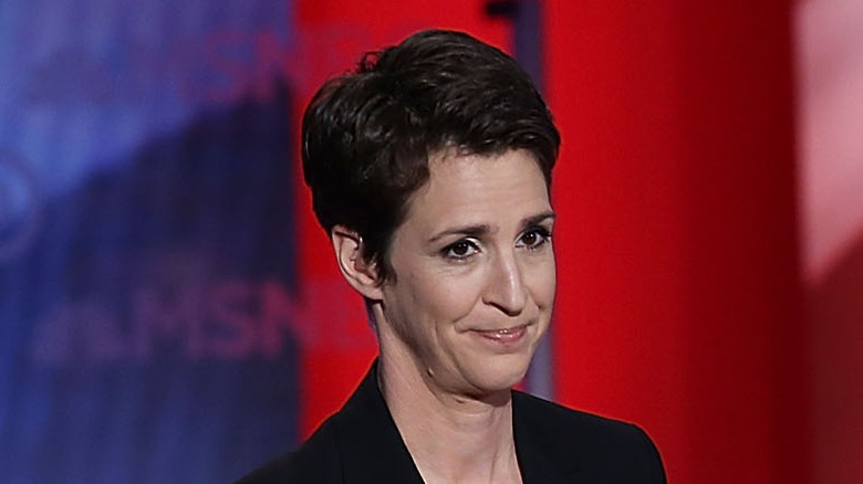 Rachel Maddow in front of a red and blue background