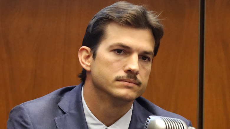 Mustached Ashton Kutcher looking glum