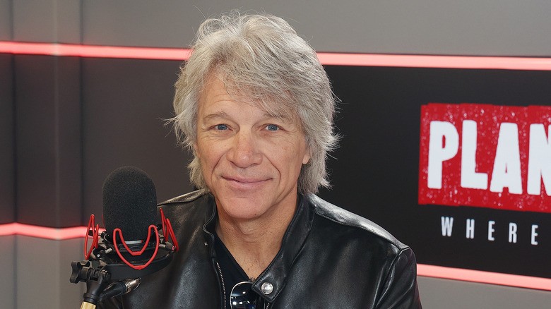 Jon Bon Jovi smiling in front of a mic