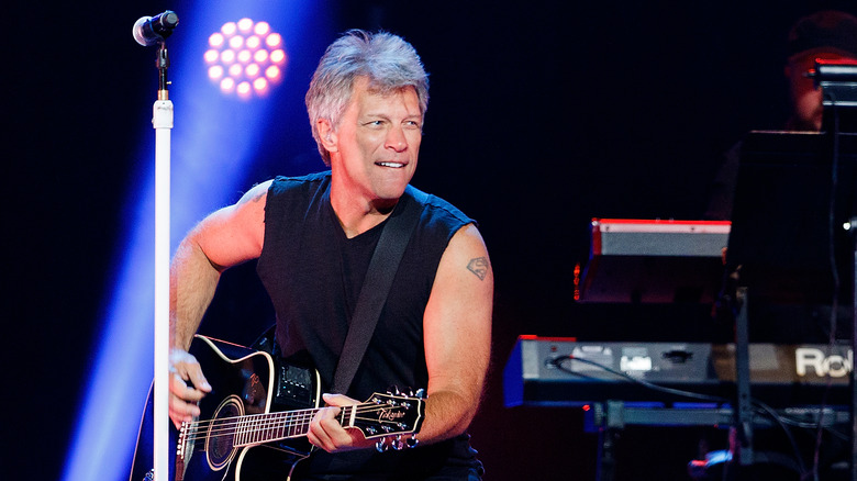 Bon Jovi playing a guitar onstage 