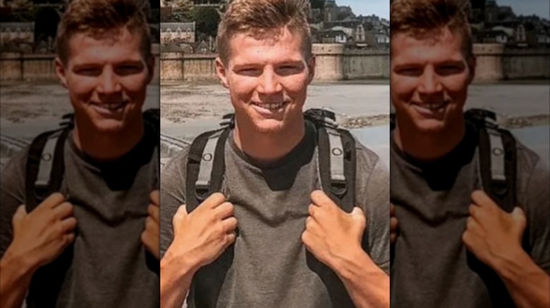 Garrison Brown smiling holding the straps of his backpack on his back