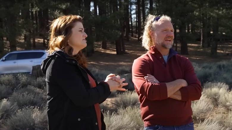 Robyn and Kody Brown standing outside among trees during an episode of Sister Wives