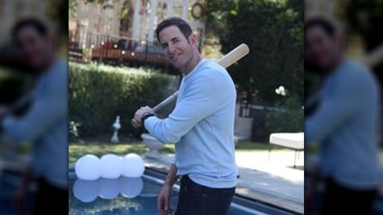 Tarek El Moussa smiling and holding a baseball bat