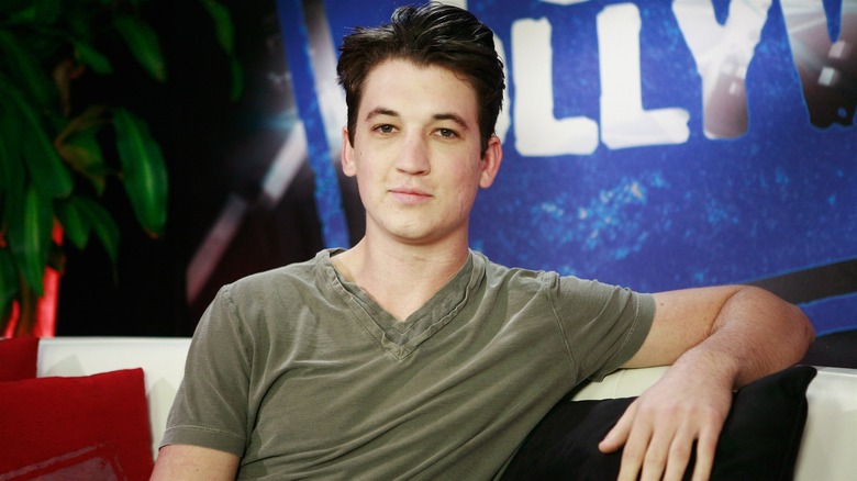 A young Miles Teller leaning back on a couch