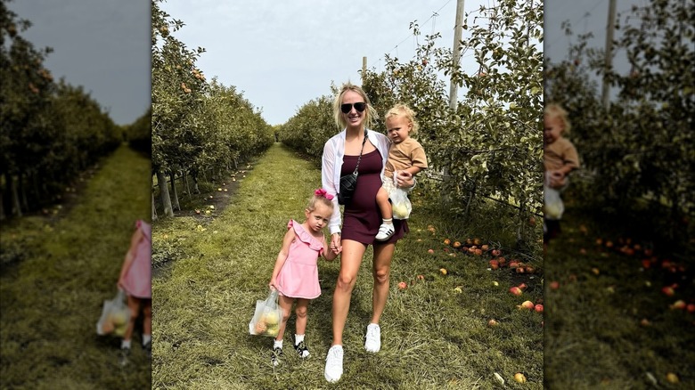 Brittany Mahomes with Sterling and Bronze in an apple orchard