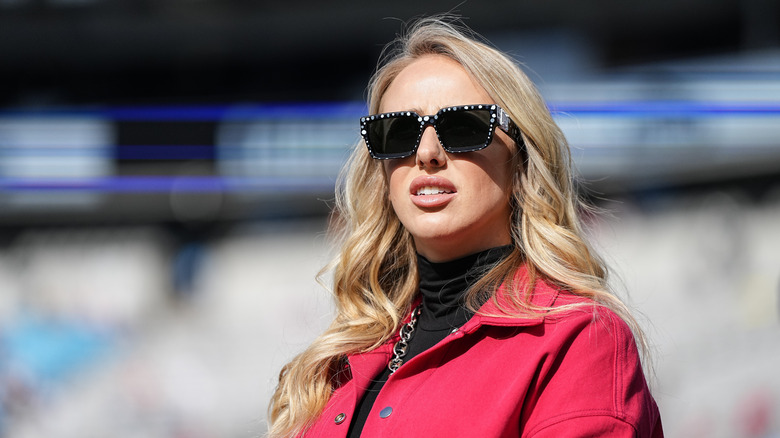 Brittany Mahomes wearing sunglasses and a red coat