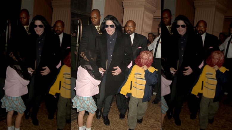 Paris and Prince Jackson wearing face coverings while walking with Michael Jackson