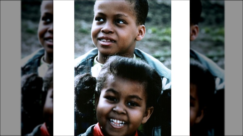 Craig Robinson looking thoughful as a child with a young Michelle Obama smiling