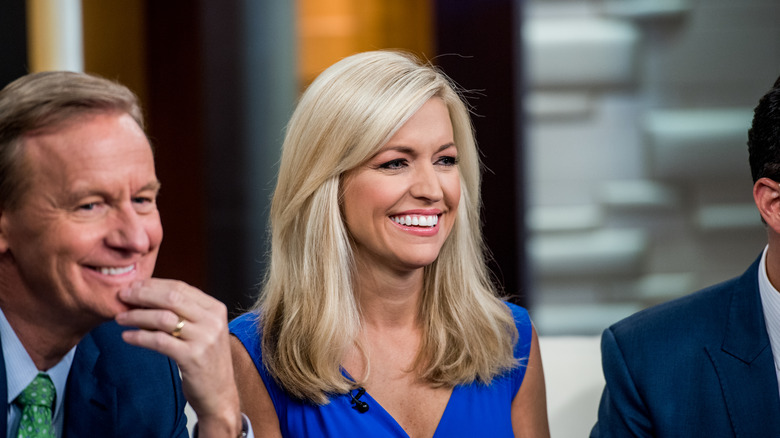 Ainsley Earhardt sitting in between co-hosts and smiling