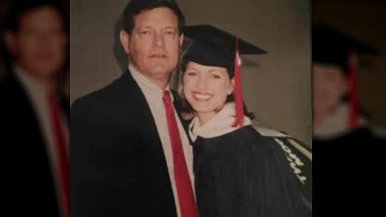 Ainsley Earhardt in graduation regalia, posing with her dad