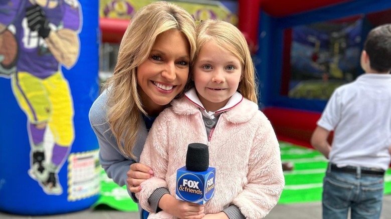 Ainsley Earhardt and her daughter posing with a microphone