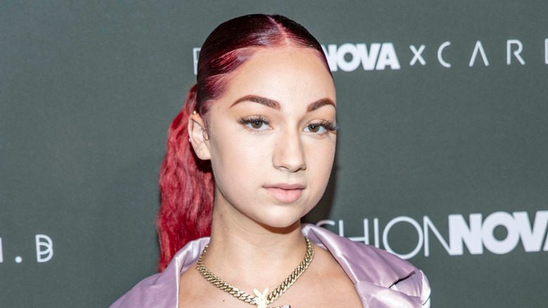 Bhad Bhabie posing with her dark red hair in a ponytail