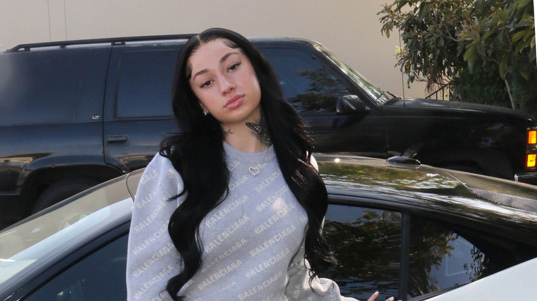 Bhad Bhabie standing in front of a car