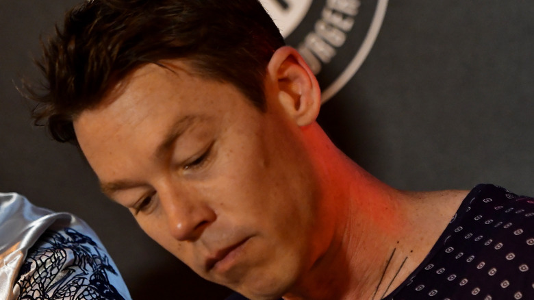 David Bromstad writing with head down