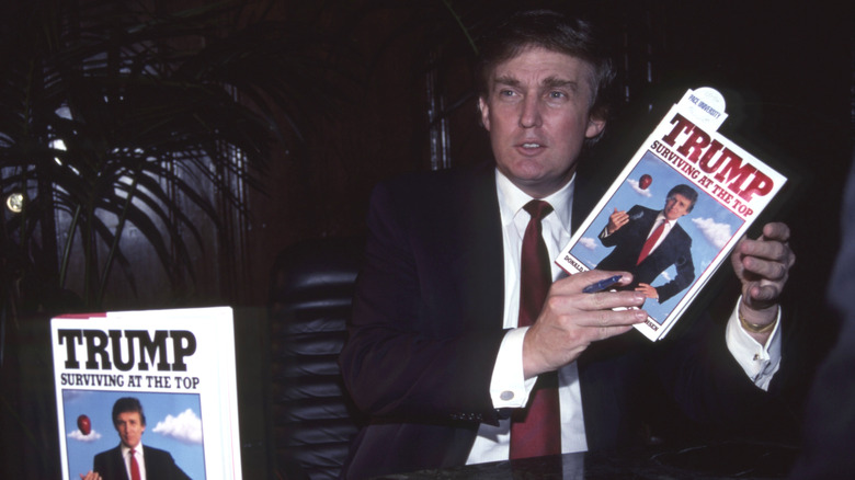 Donald Trump holding his book