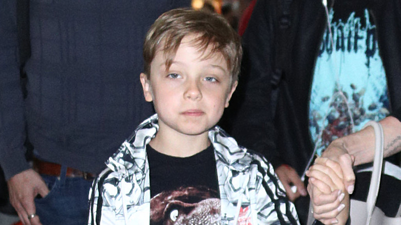 Closeup of Knox Jolie-Pitt as a child walking through airport holding Angelina Jolie's hand