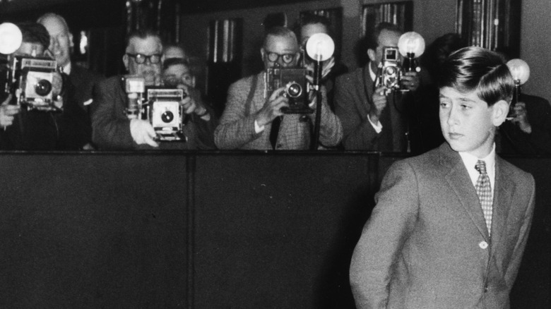 Young Prince Charles standing in front of the press