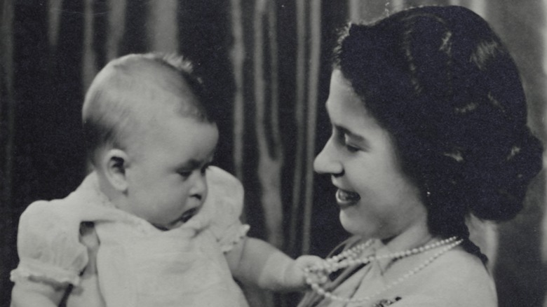 Baby King Charles being held by Queen Elizabeth