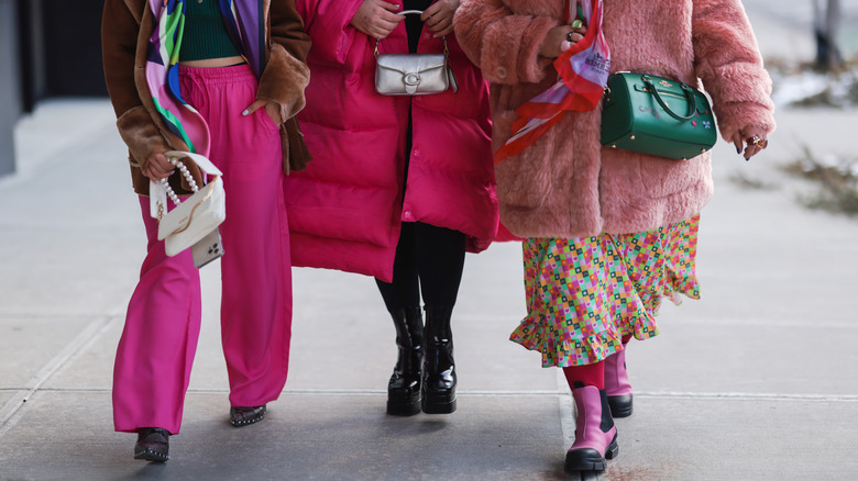 models walking down a city street wearing hot pink