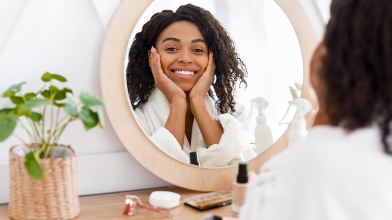 woman applying makeup in the mirror