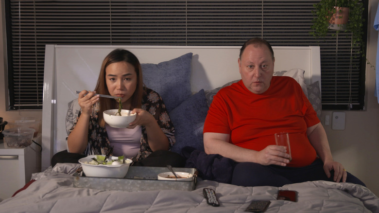 David Toborowsky and Annie Suwan eating in bed