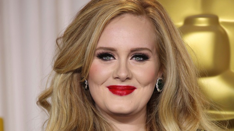 Adele smiles with red lipstick