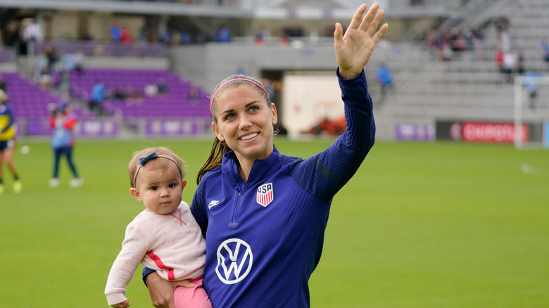 Alex Morgan and daughter charlie on the pitch