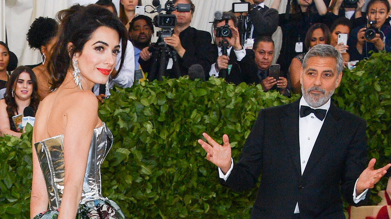 Amal and George Clooney posing on the red carpet