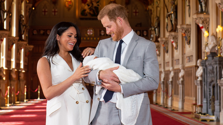 Harry and Meghan smiling at baby Archie