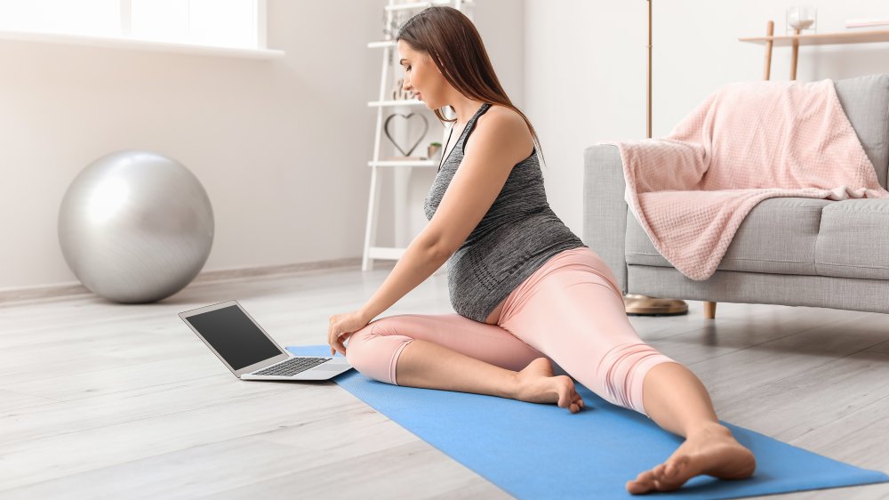 pregnant woman doing yoga at home during pandemic